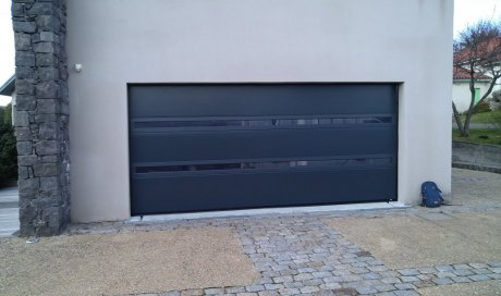 Remplacement d'une porte de garage sectionnelle avec hublot panoramique de la marque Flip (La toulousaine) motorisée Somfy io en Aluminium à Orcines (63870).